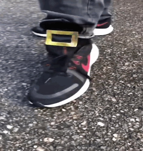 A Person Wearing A Pair Of Nike Shoes With A Gold Buckle GIF