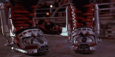 A Person Wearing A Pair Of Red And Silver Boots With The Letter N On The Bottom GIF
