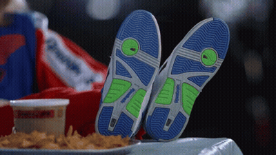 A Person Wearing A Pair Of Reebok Shoes Laying On A Table GIF