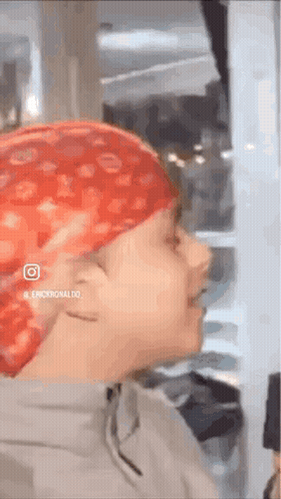 A Person Wearing A Red Bandana On Their Head Is Standing In A Room . GIF