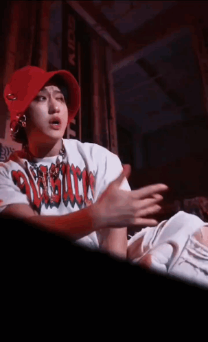 A Person Wearing A Red Hat And A White Shirt That Says ' Assault ' GIF
