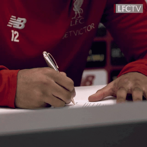 A Person Wearing A Red Shirt With The Number 12 On It Is Writing On A Piece Of Paper GIF