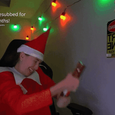 a person wearing a santa hat is sitting in front of a sign that says ' esubbed for months '