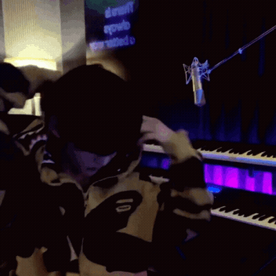 A Person Wearing A Shark Hoodie Stands In Front Of A Piano GIF