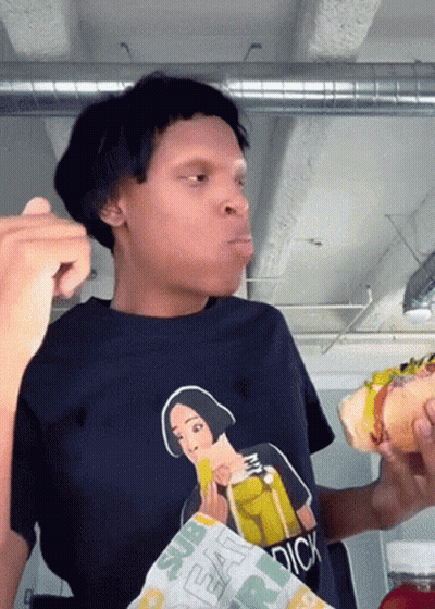 A Person Wearing A Shirt That Says Dick Is Eating A Sandwich GIF