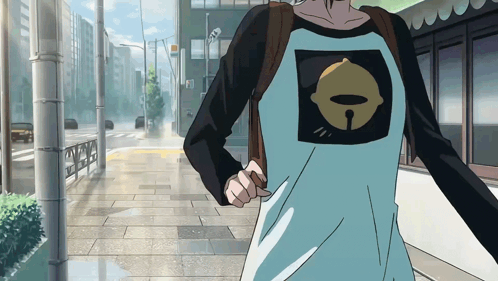 A Person Wearing A Shirt With A Bell On It Is Walking Down The Street GIF