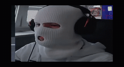 A Person Wearing A Ski Mask And Headphones Looks At The Camera GIF