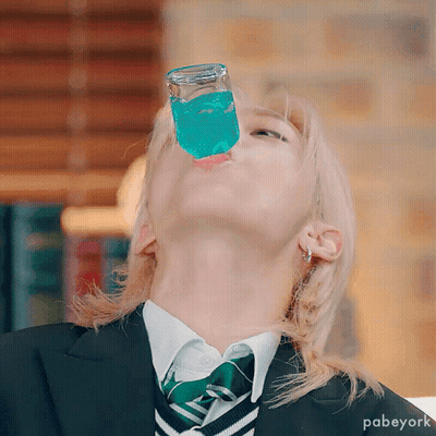 A Person Wearing A Suit And Tie Is Drinking From A Glass GIF