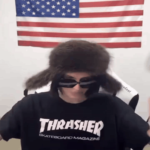 A Person Wearing A Thrasher Skateboard Magazine Shirt And Sunglasses GIF
