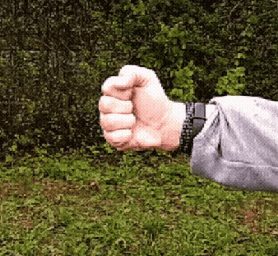 A Person Wearing A Watch Is Giving A Thumbs Up In The Grass GIF