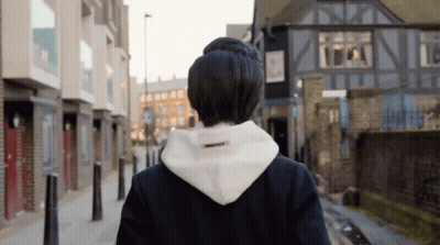 A Person Wearing A White Hoodie That Says Essentials On The Back GIF