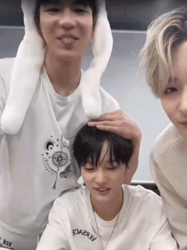 A Person Wearing A White Shirt That Says Aebvce Holds Another Person 'S Head GIF