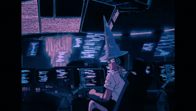 A Person Wearing A Witch Hat Is Sitting In Front Of A Computer Monitor GIF
