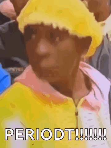 A Person Wearing A Yellow Hat And A Yellow Jacket Is Sitting In A Crowd . GIF