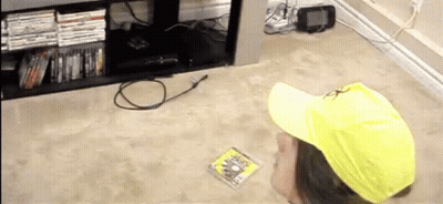 A Person Wearing A Yellow Hat Is Looking At A Dvd GIF