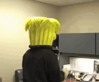 A Person Wearing A Yellow Wig Is Standing In A Room GIF