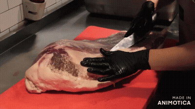 A Person Wearing Black Gloves Is Cutting A Large Piece Of Meat On A Red Cutting Board Made In Animotica GIF