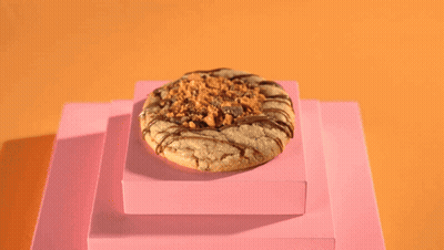 A Person Wearing Black Gloves Pours A Cookie With A Spoon GIF