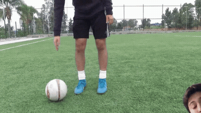 A Person Wearing Blue Adidas Shorts Kicks A Soccer Ball GIF