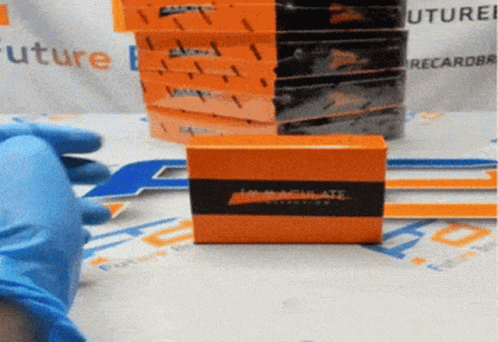 A Person Wearing Blue Gloves Is Holding An Orange Box That Says Inactivate On It GIF