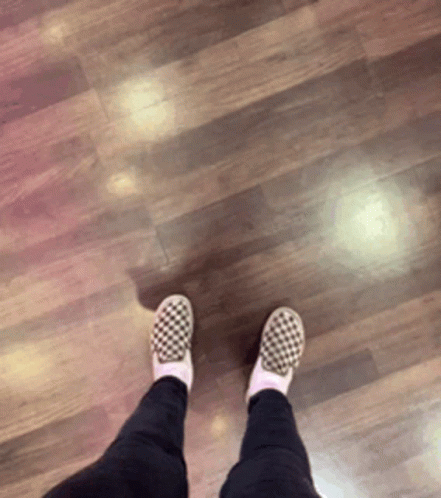 A Person Wearing Checkered Shoes Standing On A Wood Floor GIF
