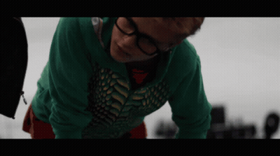 A Person Wearing Glasses And A Green Shirt Is Laying On Their Back GIF