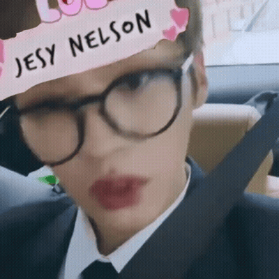 A Person Wearing Glasses And A Headband With Jesy Nelson Written On It GIF