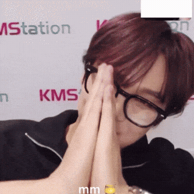 A Person Wearing Glasses Is Covering Their Face In Front Of A Kms Sign GIF
