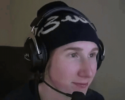 A Person Wearing Headphones And A Beanie With The Number 3 On It Is Smiling . GIF