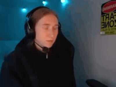A Person Wearing Headphones And A Microphone Is Sitting In Front Of A Computer . GIF