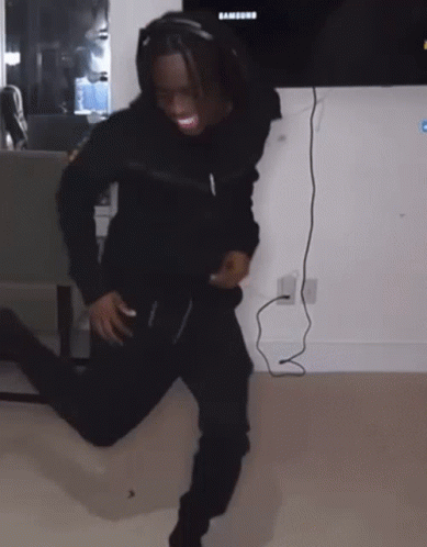 A Person Wearing Headphones Is Dancing In Front Of A Samsung Television GIF