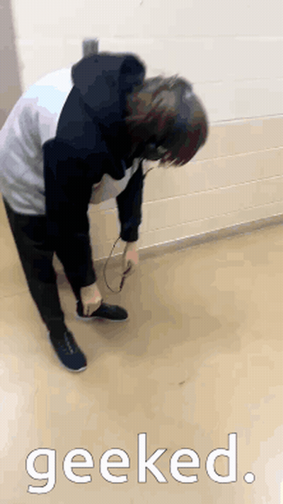A Person Wearing Headphones Is Kneeling On The Floor With The Word Geeked Above Them GIF