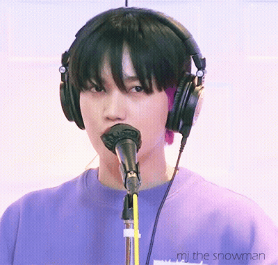 A Person Wearing Headphones Is Singing Into A Microphone With The Words " Mj The Snowman " Below Them GIF