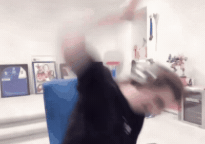 A Person Wearing Headphones Is Sitting At A Desk In A Room With Pictures On The Wall . GIF