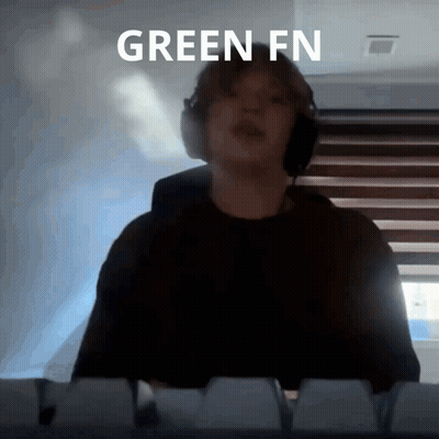 A Person Wearing Headphones Is Standing In Front Of A Keyboard With The Words Green Fn Written Above Them GIF