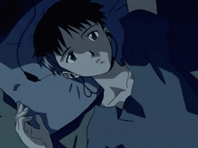 A Person Wearing Headphones Laying On A Bed With A Blue Shirt On GIF