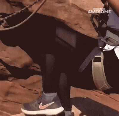 A Person Wearing Nike Shoes Climbs A Rocky Hillside GIF
