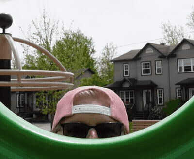 A Person Wearing Sunglasses And A Pink Hat Looks Out Of A Green Circle GIF