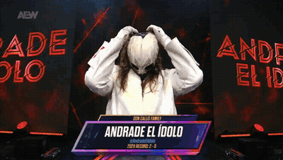 A Person With A Mask On Stands In Front Of A Sign That Reads Andrade El Idolo GIF
