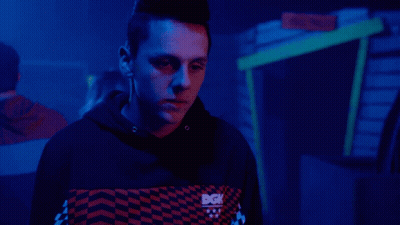 A Person With A Mohawk Stands In Front Of A Cactus GIF