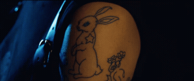 A Person With A Tattoo Of A Rabbit And Flowers On Their Arm GIF