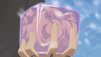 A Person With A Tattoo On Their Hand Is Holding A Heart In Their Hands GIF