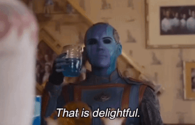 A Person With Blue Paint On Their Face Is Holding A Glass Of Water And Saying That Is Delightful GIF