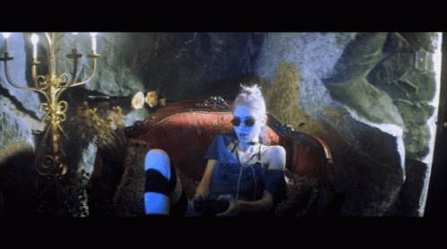 A Person With Blue Paint On Their Face Is Sitting On A Couch GIF