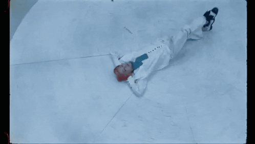 A Person With Red Hair Is Laying On The Ground GIF