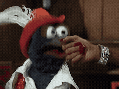 A Person With Red Nails Is Touching A Stuffed Animal With A Red Hat GIF