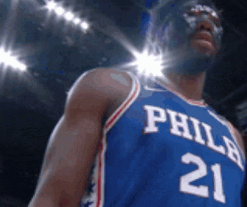 A Philadelphia Basketball Player Wearing A Mask And Jersey Number 21 GIF