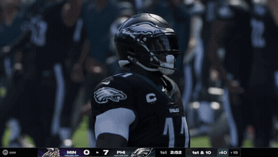 A Philadelphia Eagles Player Is Holding A Football In Front Of A Crowd GIF