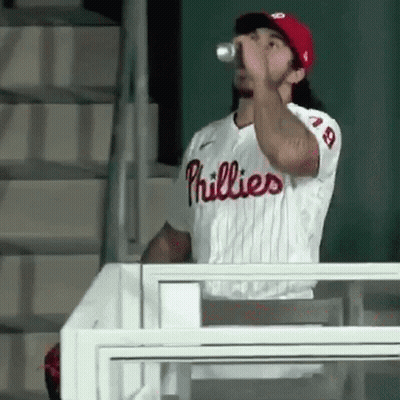 A Phillies Baseball Player Is Drinking From A Can . GIF