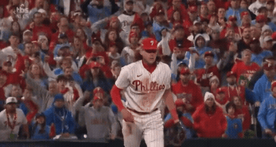 A Phillies Baseball Player Is Standing In Front Of A Crowd Of People . GIF